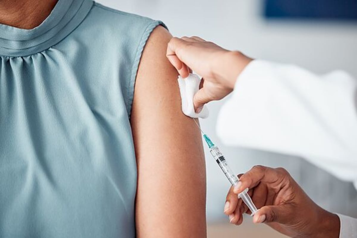 Hands, medical and doctor with patient for vaccine in a clinic for healthcare treatment for prevention. Closeup of a nurse doing a vaccination injecti
